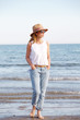 © sepy - Enjoying summer. Beautiful woman walking on beach in casual.