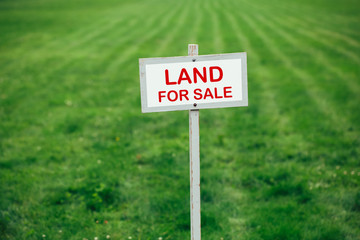 land for sale sign against trimmed lawn background