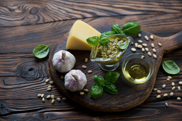 Wall Mural - Basil pesto sauce and ingredients in a rustic wooden setting