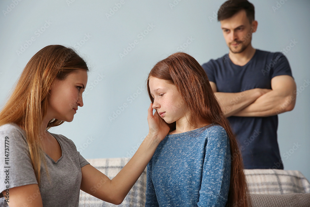 Family problems concept. Angry father and mother becalming girl