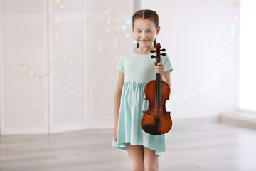 Wall Mural - Little girl with violin on light background