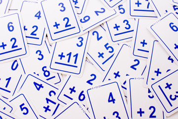 education: blue addition math cards randomly spread out on table. educational school supplies. edica