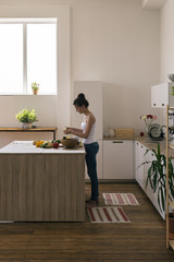 Barefoot housewife cooking in kitchen