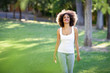 © javiindy - Young black woman with afro hairstyle smiling in urban park