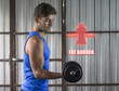 © GENETTICA - Fat burner concept with icon of two arrows narrowing a bottle and young man lifting weights with his right arm during a workout at a gym located in a garage.