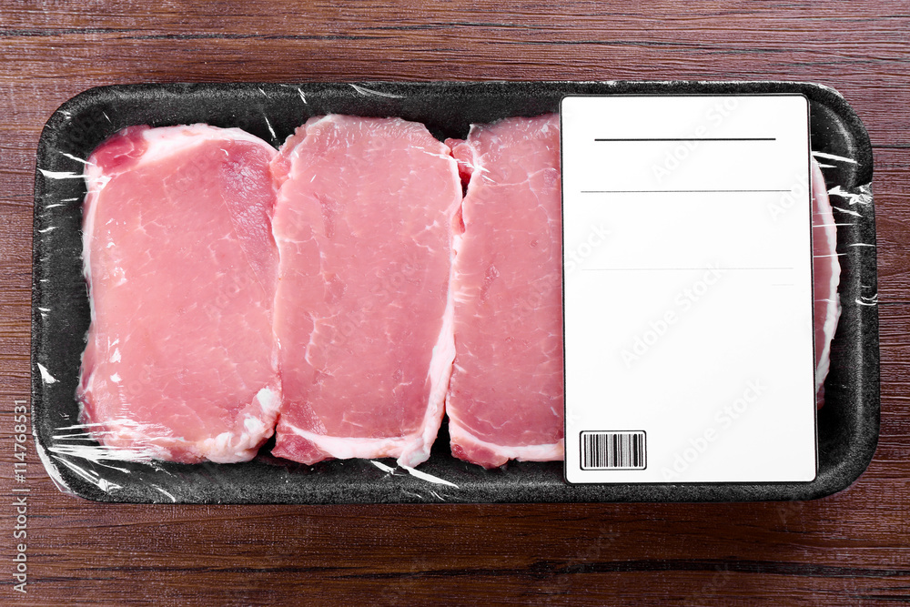 Packed pieces of pork meat on wooden background