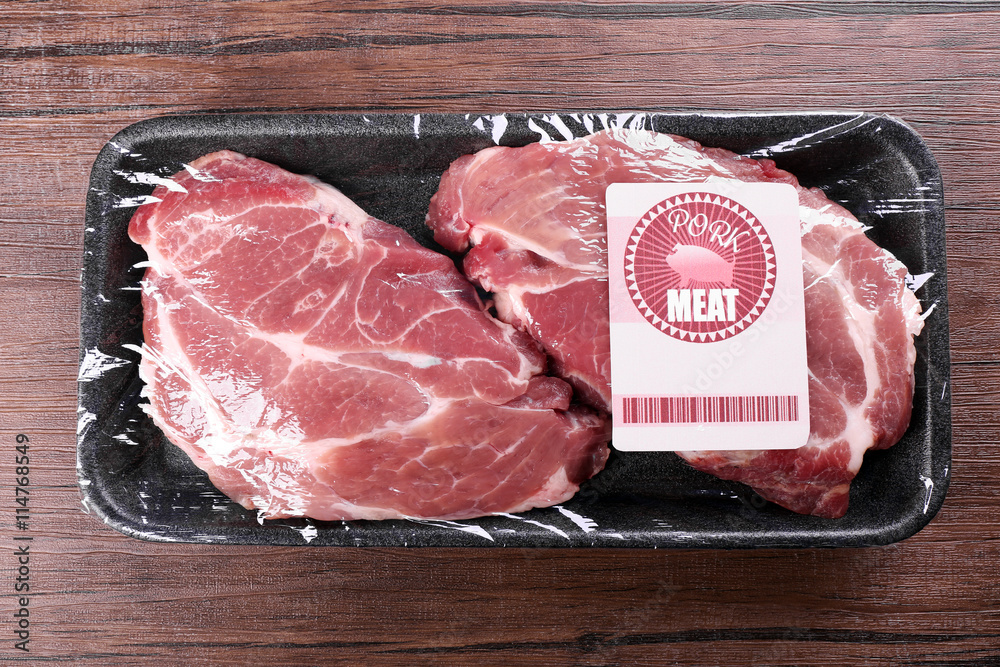 Packed pieces of pork meat on wooden background