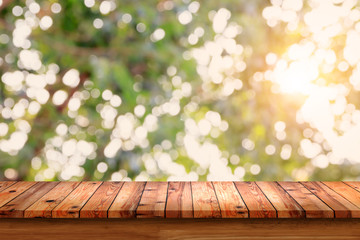 Poster - Empty wooden table with bokeh abstract green background.