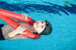 © Tatiana Murr - Happy  boy swimming with a red foam noodle in a indoor pool
