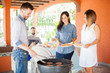 © AntonioDiaz - Friends standing at the grill in a barbecue