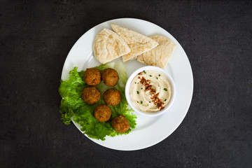 Wall Mural - Vegetarian falafels and hummus on black slate

