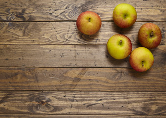 Red apples on a rustic wooden background forming a page border