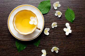 Jasmine tea in a porcelain Cup on a dark wood