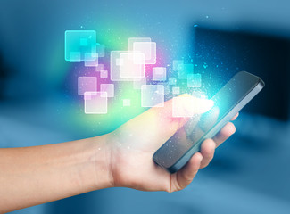 Aufkleber - Hand holding smart phone with abstract glowing squares