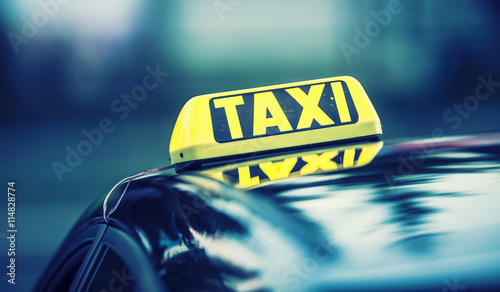 Plakat Taksówki czekają pasażerów w mieście. Światło taksówki w kabinie samochodu gotowego do transportu pasażerów.
