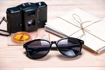 Sunglasses, compass, old film camera and a bunch of letters on l