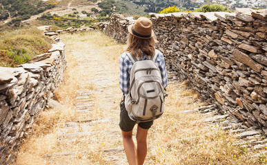 Wall Mural - Hiker traveler woman on a hiking trail, travel and active lifestyle concept