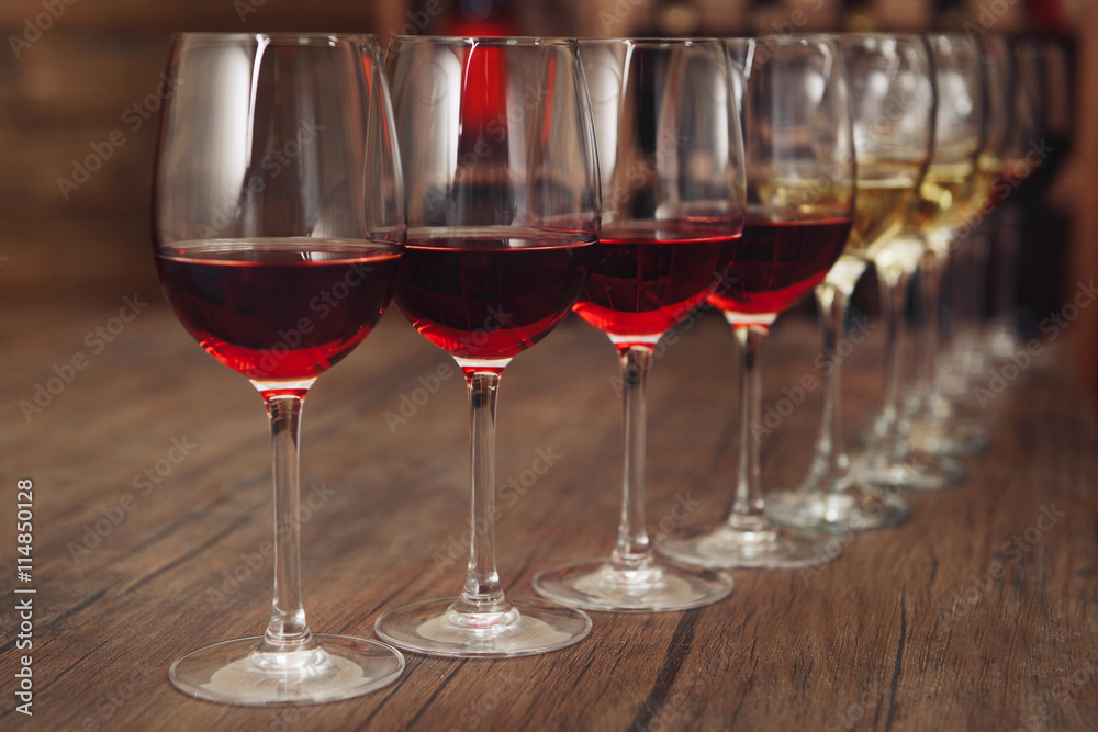 Many glasses of different wine in a row on bar counter