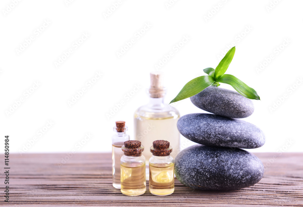 Gray spa stones with oil on light background