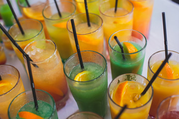 View of alcohol setting on catering banquet table, row line of different colored alcohol cocktails on a party, martini, vodka, and others on decorated catering bouquet table event