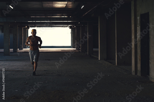 Fotografia Male athlete running on industrial building, fitness