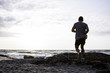 © serejkakovalev - Young sporty man with tattoo running on beach in sunrise light