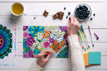 Flat lay, female coloring adult coloring books, new stress relieving trend