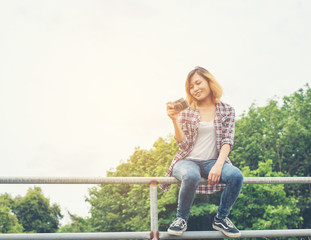 Wall Mural - Young beautiful hipster woman holding retro camera outside with