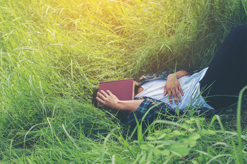 Young hipster man lying down on grassland napping tired after re