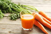 Fresh Carrot Juice In Glass On A Grey Wooden Table