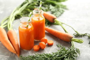 Canvas Print - Fresh carrot juice in bottles on a grey background