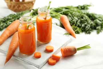 Canvas Print - Fresh carrot juice in bottles on a white wooden table