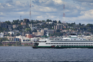 Wall Mural - Seattle Skyline. A summertime view of the Seattle skyline looking from west Seattle across Elliott Bay. Cruise ships, ferryboats, tugboats, and freighters are a common sight in this maritime city.