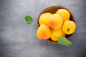 Apricots with leaves on the old wooden table.