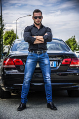 Handsome bearded man next to car in sunglasses