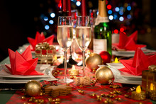 Christmas Eve Party Table With Champagne Flute With Red And Golden Glitter