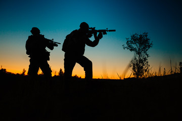 Silhouette of military soldiers with weapons at night. military concept.