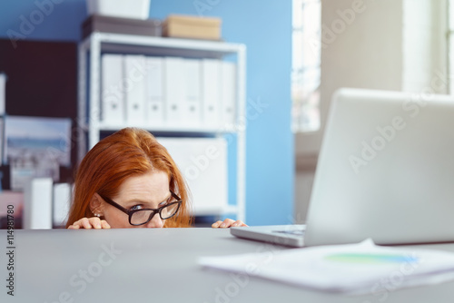 Fotografía frau im büro versteckt sich unter dem schreibtisch