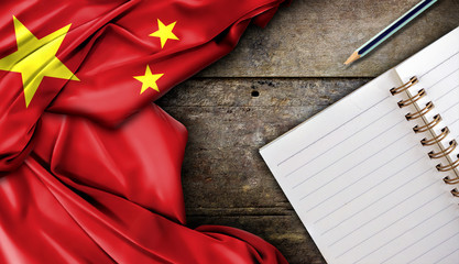 Wall Mural - China flag and notebook on wooden table, high contrast and over light