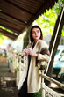 © okostia - Stylish brunette with cup of coffee on background of summer cafe
