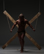 © kazanovskyiphoto - Sexual naked man, muscular, hands tied rope to wooden beams