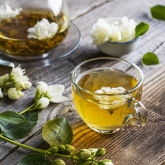 cup of green tea infused with jasmine on a gray wooden background