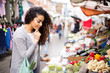 © michael spring - young woman shopping at the market