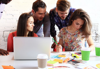 Canvas Print - Making great decisions. Young beautiful woman gesturing and discussing something with smile while her coworkers listening to her sitting at office table