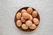 Eggs in wooden bowl on linen background