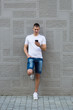 © bnenin - Young casual man using a smart phone texting messages in the str