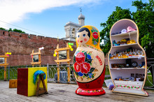 Belfry Of St Sophia Cathedral With Big Colorful Russian Doll Matrioshka On The Foreground And Souvenirs In Veliky Novgorod, Russia
