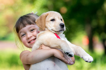 Little girl with a Golden retriever puppy