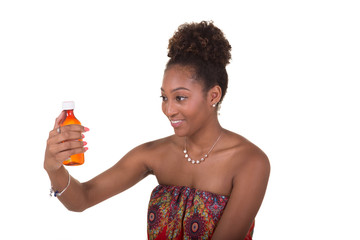 Young woman holding and reading the label on a pill bottle