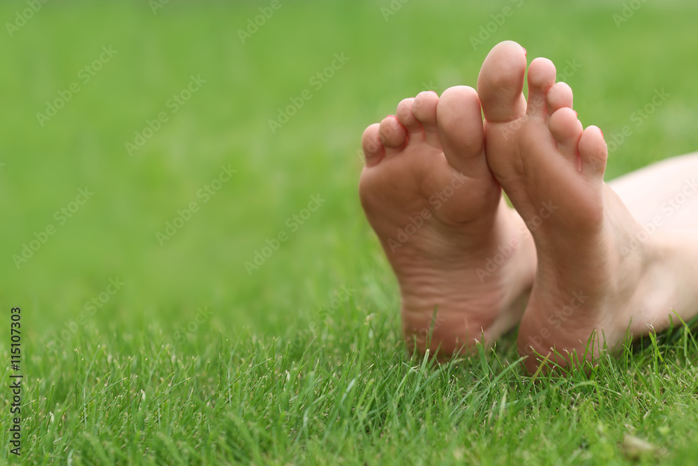 Woman legs on green grass, closeup